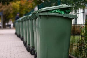 szereg zielonych kontenerów na odpady
